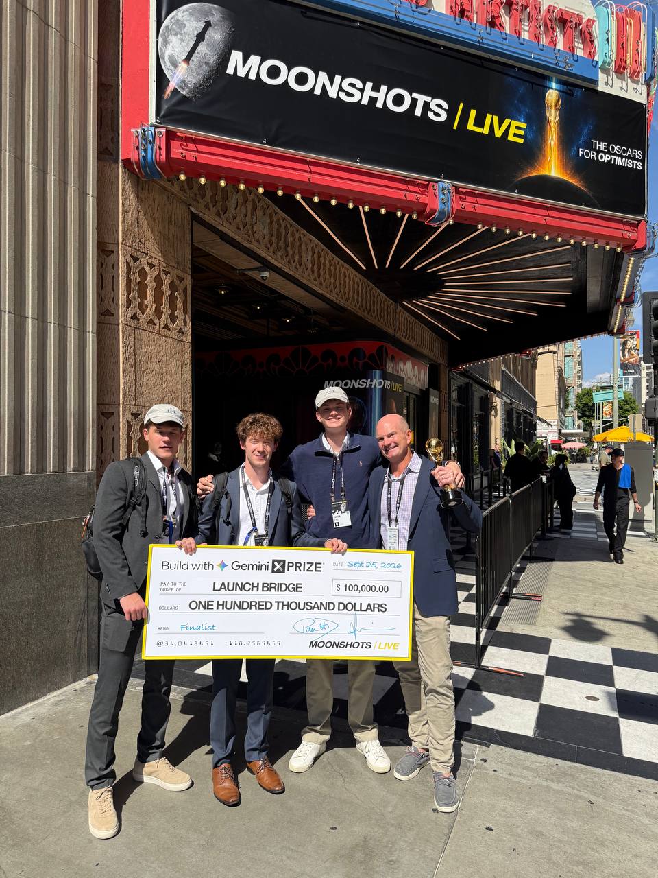 Bryan Eckle with the three LaunchBridge founders outside Moonshots Live holding their $100,000 Build with Gemini XPRIZE finalist check